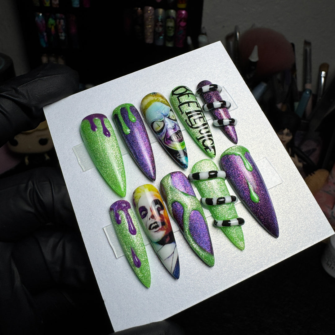 Green and purple striped press-on nails with raised 3D sandworm details