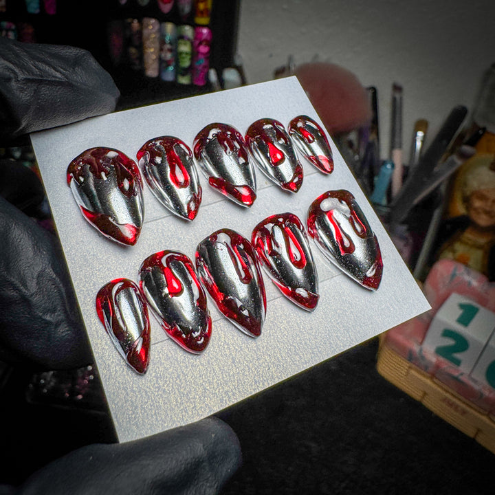 Silver chrome press-on nails with red blood-drip designs