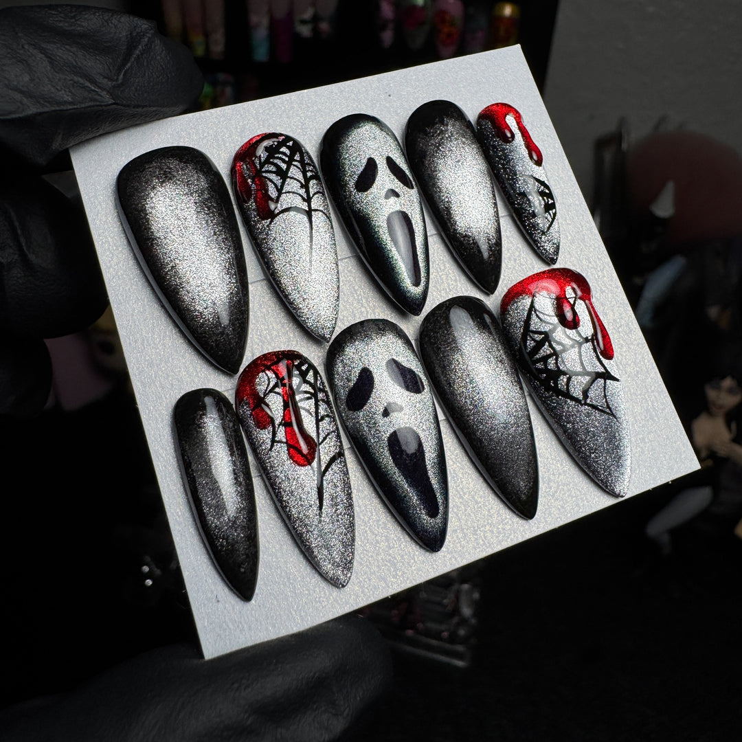 Silver cat-eye Ghostface press-on nails with spiderweb and blood designs