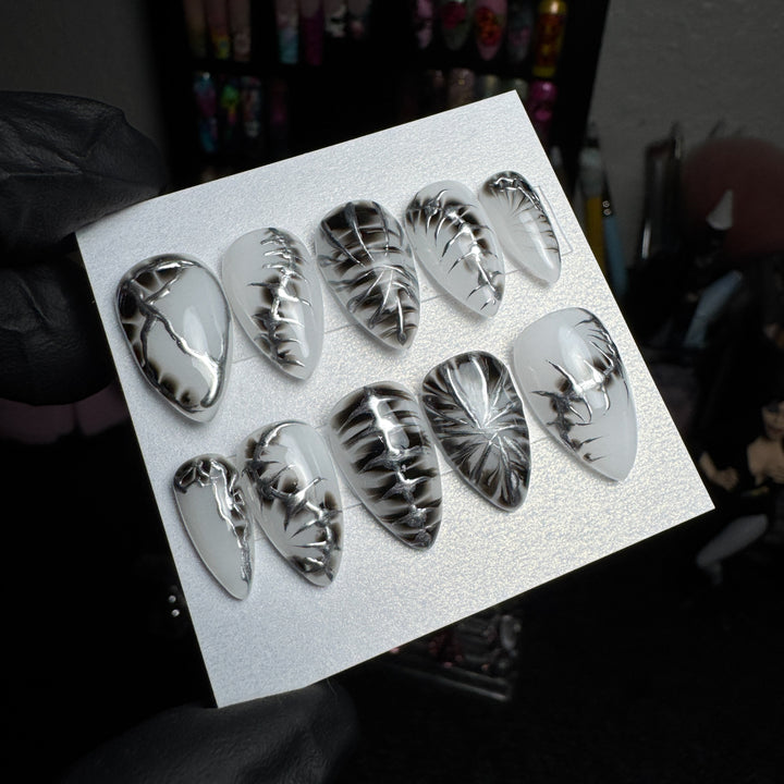 White and silver press-on nails with stitched anatomy designs