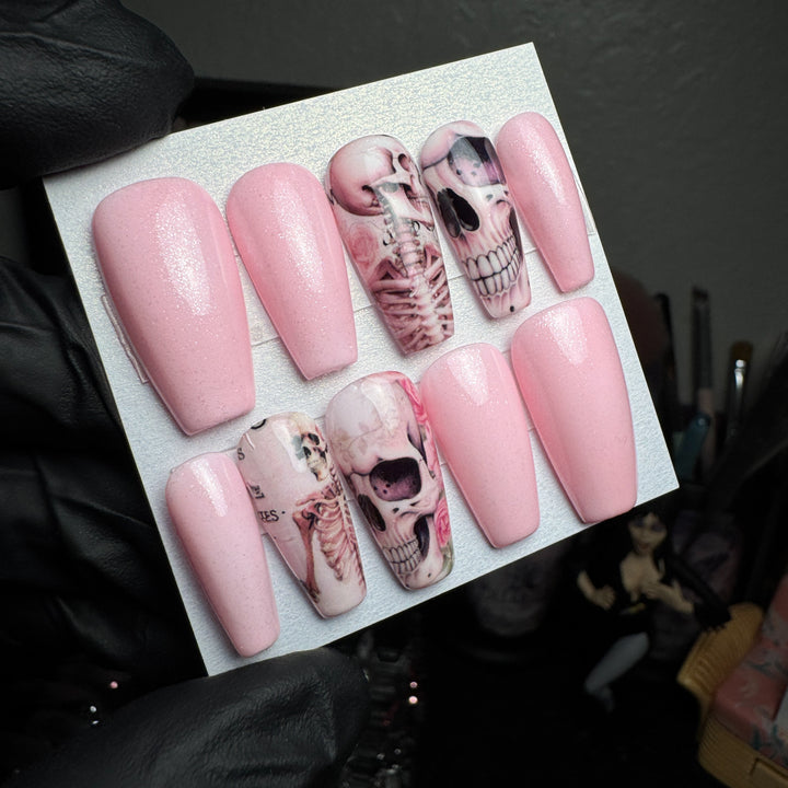 Glittery pink press-on nails with creepy anatomy and skull accent designs